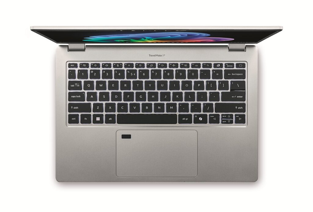 Top-down view of a silver laptop open to reveal a black keyboard and colorful screen wallpaper on a white background.