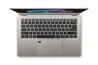Top-down view of a silver laptop open to reveal a black keyboard and colorful screen wallpaper on a white background.