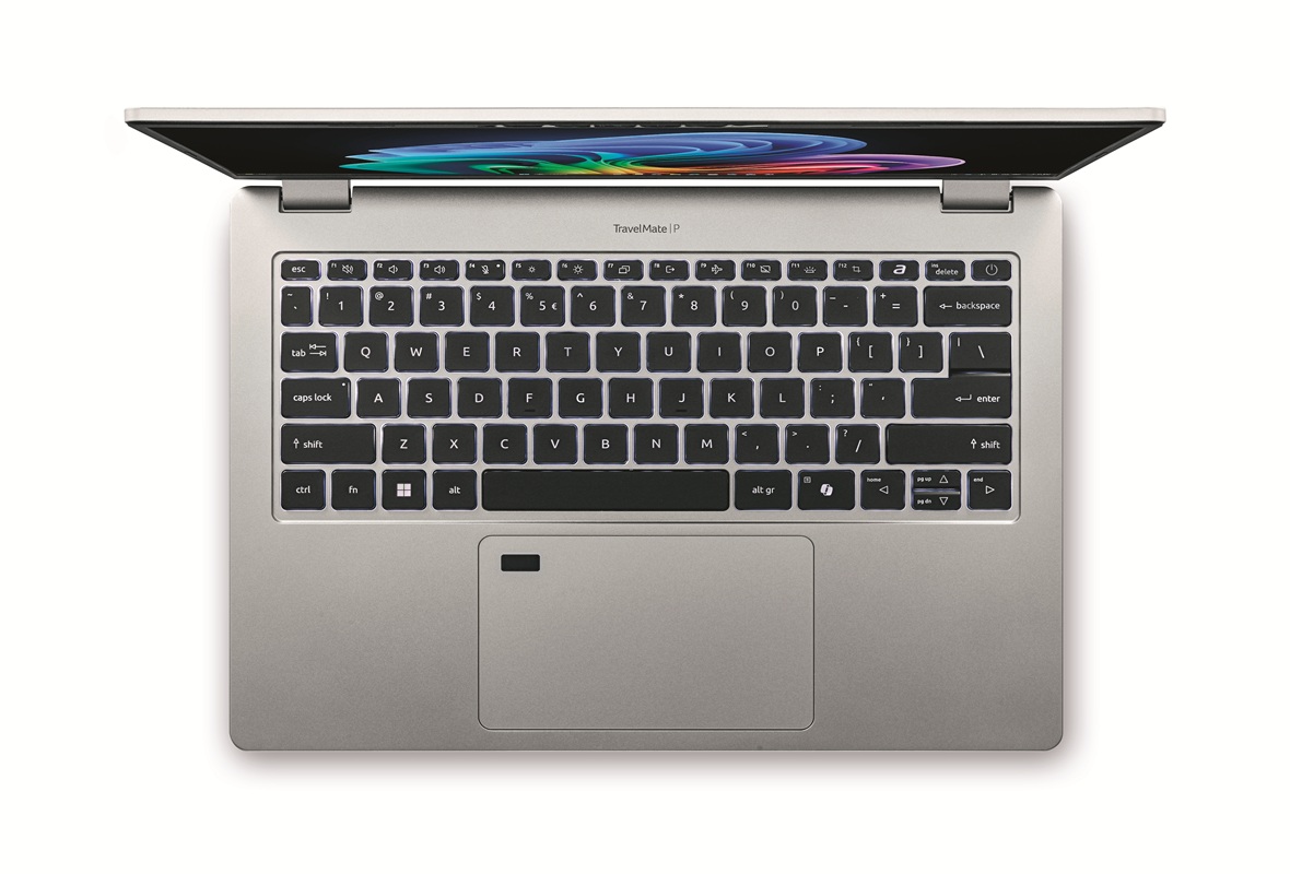 Top-down view of a silver laptop open to reveal a black keyboard and colorful screen wallpaper on a white background.