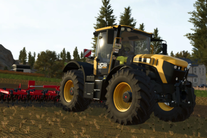 Yellow JCB tractor with large off-road tires pulling red cultivator in a harvested field with trees and farm buildings in the background.
