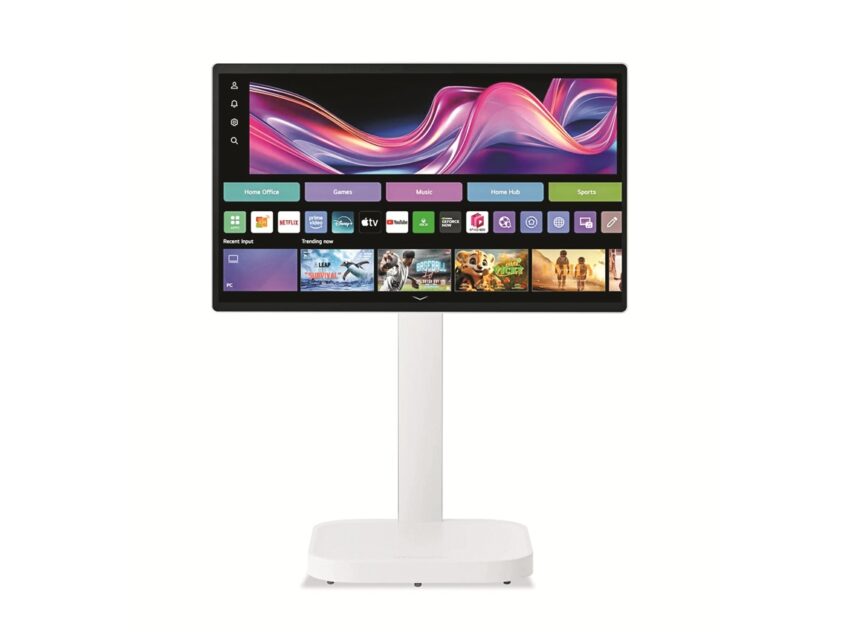 Widescreen monitor on a white stand showing a colorful home-screen interface with app tiles and icons.