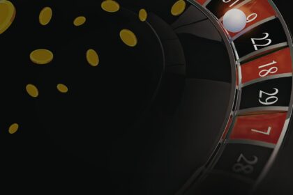 Roulette wheel in motion with gold coins scattering across a dark background
