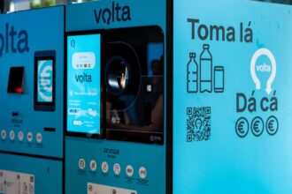 Public bottle-return kiosk with blue Volta branding, touch screen, and a QR code