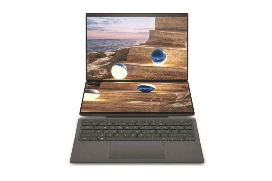 Dual-screen laptop with a coastal rock staircase image displayed across both open screens and a dark gray keyboard below.