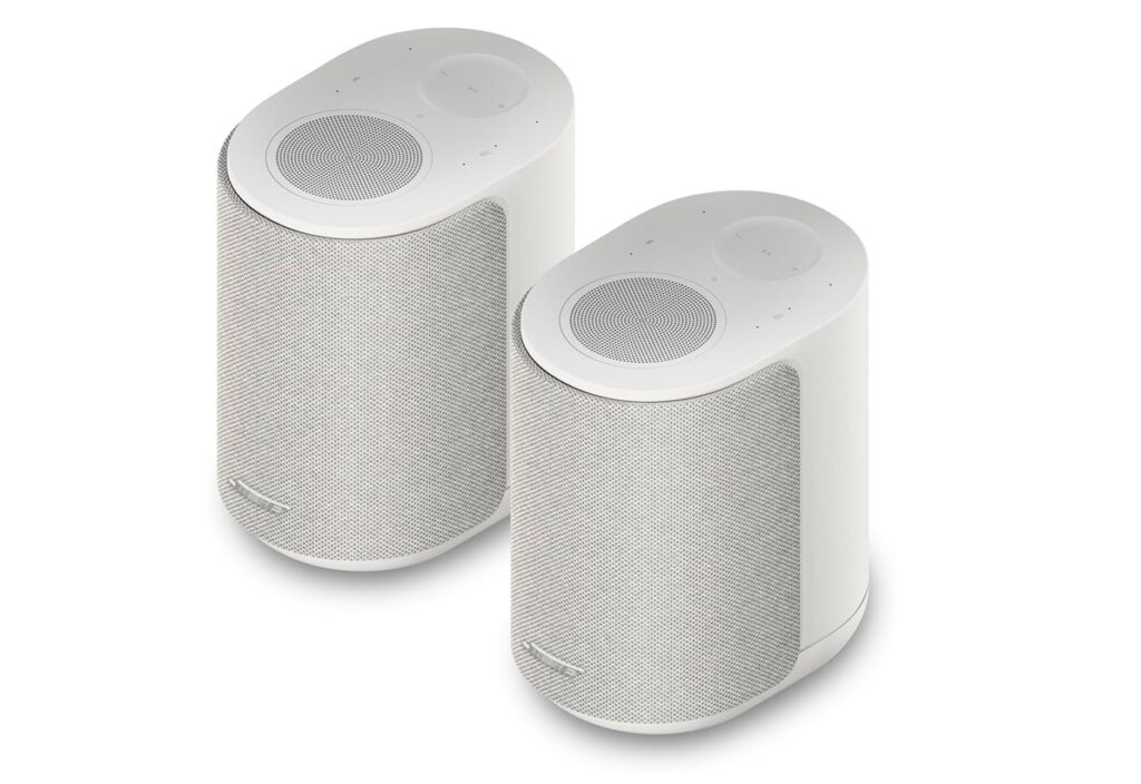 Pair of white cylindrical wireless speakers with mesh fronts, shown at an angle on a white background.