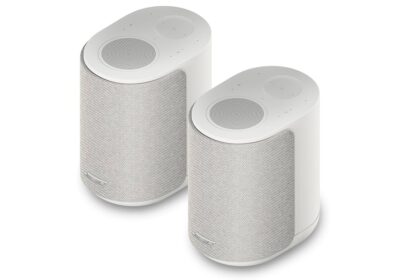Pair of white cylindrical wireless speakers with mesh fronts, shown at an angle on a white background.