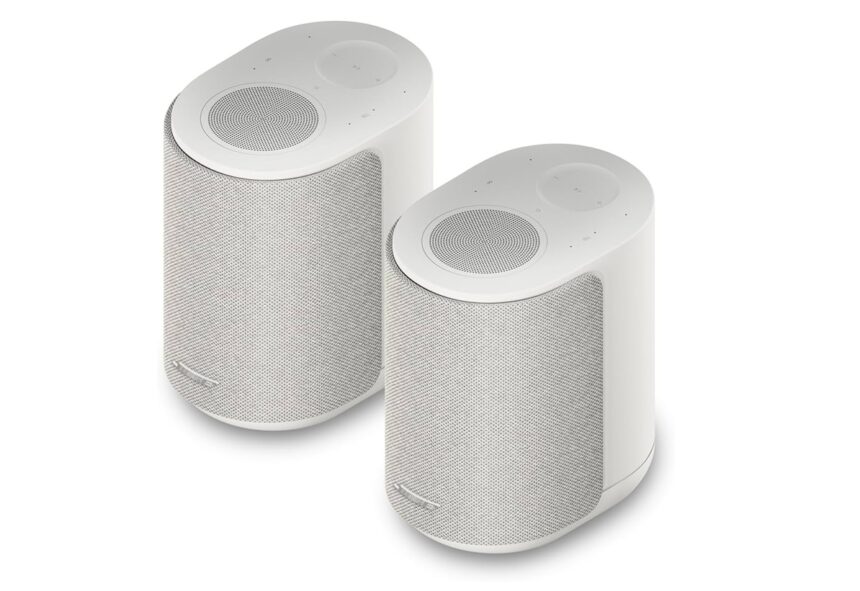 Pair of white cylindrical wireless speakers with mesh fronts, shown at an angle on a white background.