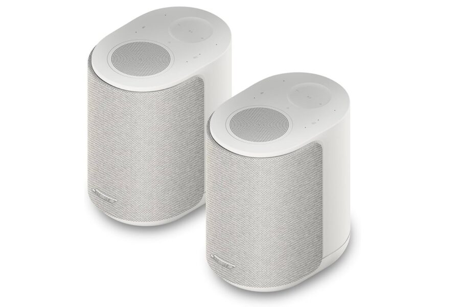 Pair of white cylindrical wireless speakers with mesh fronts, shown at an angle on a white background.