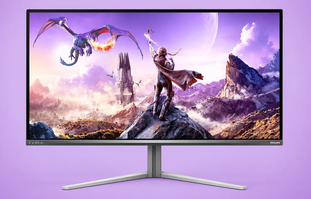 Monitor screen showing a fantasy landscape: a knight stands on a rocky peak as a dragon flies above purple skies and distant mountains.