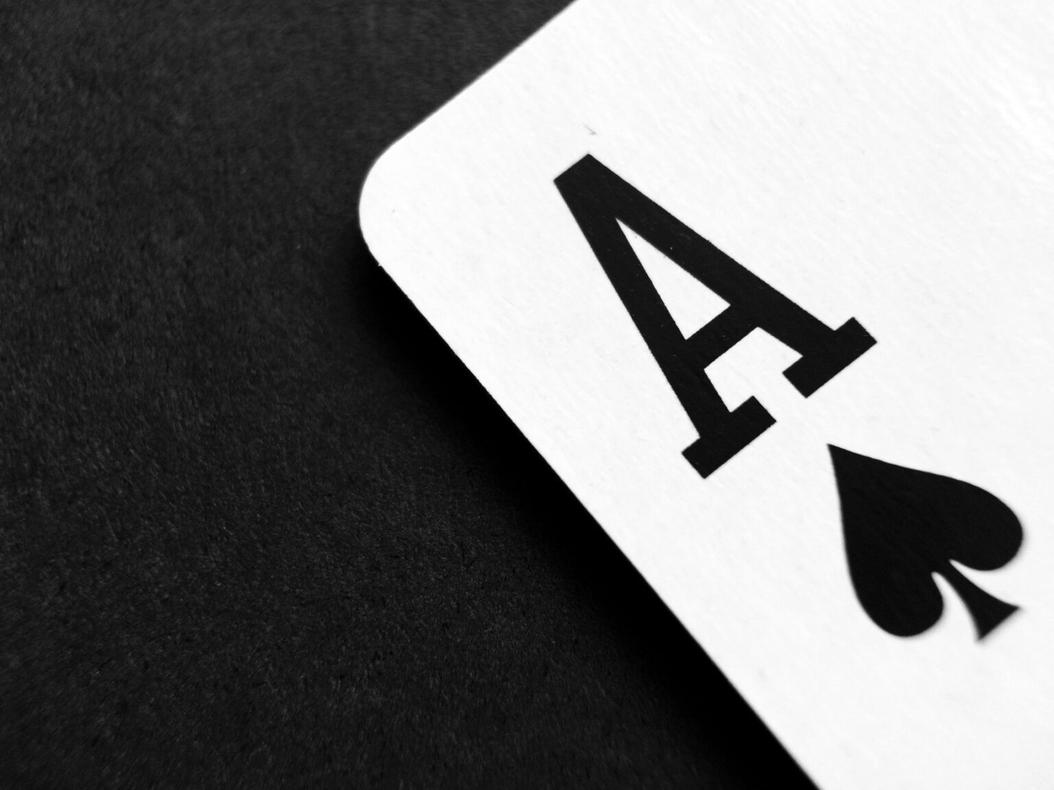 Close-up of a white card showing a bold black 'A' on a dark surface.
