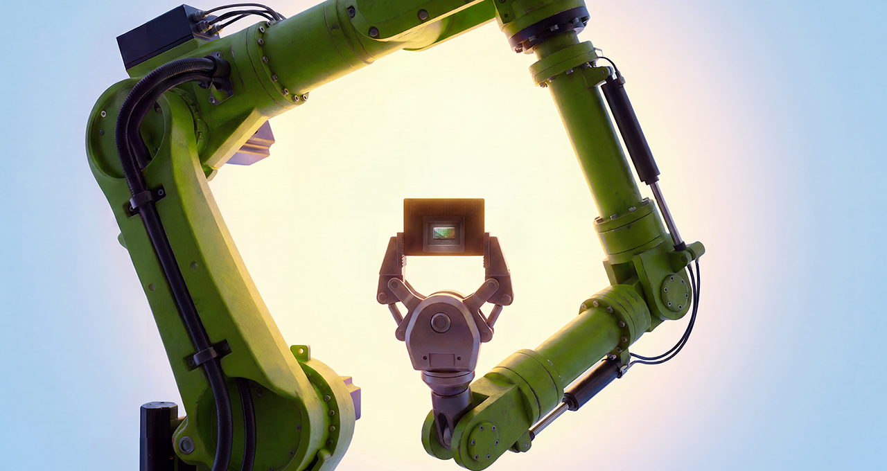 Green industrial robotic arm with a claw-like end effector, forming a circular frame against a bright sky