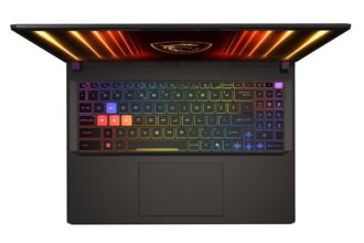 Top-down view of a black gaming laptop with a rainbow RGB keyboard lighting up the keys and a glowing screen edge above the keyboard