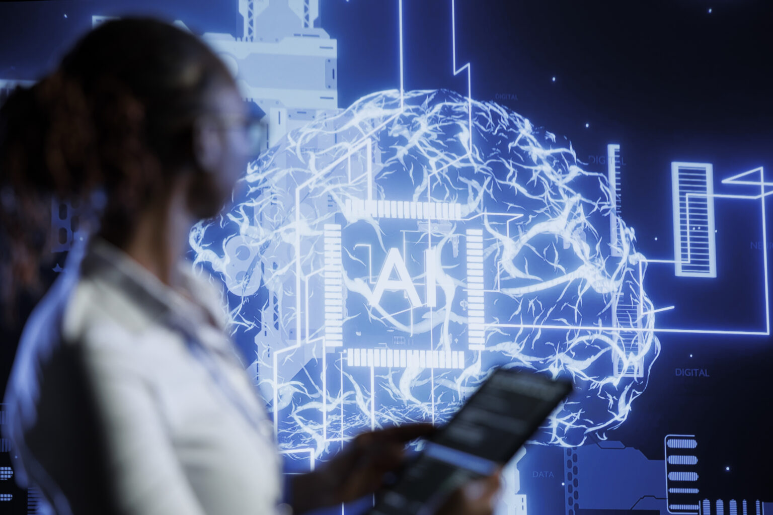 Person in the foreground uses a tablet as a blue holographic globe and digital network graphics glow in the background. This conveys a futuristic data visualization scene.