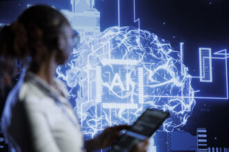 Person in the foreground uses a tablet as a blue holographic globe and digital network graphics glow in the background. This conveys a futuristic data visualization scene.