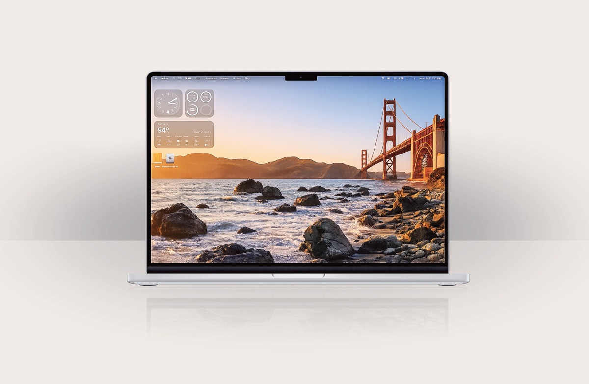 Silver laptop open to a sunset scene of the Golden Gate Bridge over rocky shore with widgets on the left side of the screen.