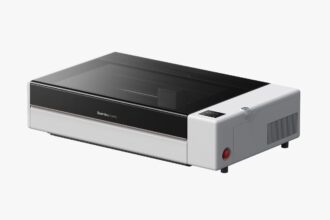 Desktop 3D printer with a black front panel and transparent lid, brand 'Bambu Lab' visible on the front edge.