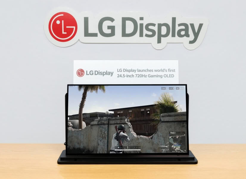 LG Display logo on the wall above a laptop showing a first-person shooter game on screen.