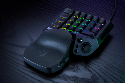 RGB-lit compact gaming keypad with a curved palm rest on a dark desk contextually highlighting its use for gaming setup.