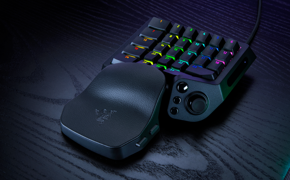 RGB-lit compact gaming keypad with a curved palm rest on a dark desk contextually highlighting its use for gaming setup.