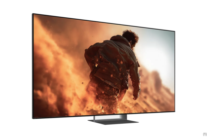 Flat-screen TV on a low stand displaying a man running through orange smoke and flames in an action scene