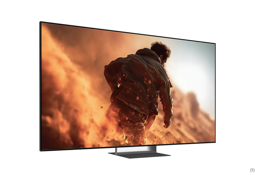 Flat-screen TV on a low stand displaying a man running through orange smoke and flames in an action scene