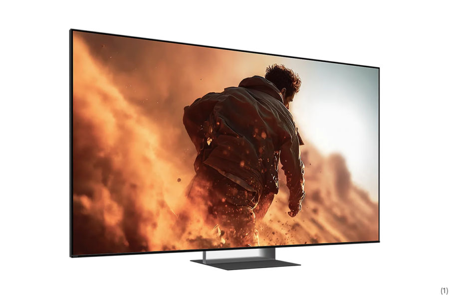 Flat-screen TV on a low stand displaying a man running through orange smoke and flames in an action scene