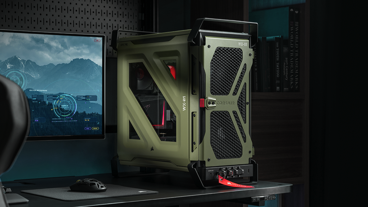 Olive-green Corsair PC tower with protective frame on a desk beside a monitor displaying a sci-fi HUD screenshot.