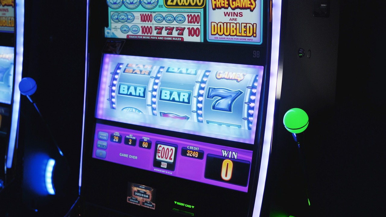 Bright casino slot machine with three reels showing BAR symbols and a large 7, purple-lit panel and blue LED edges.