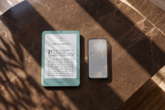 Two e-readers (one teal Kindle, one darker device) sit on a brown marble table with dramatic shadows and sunlight.